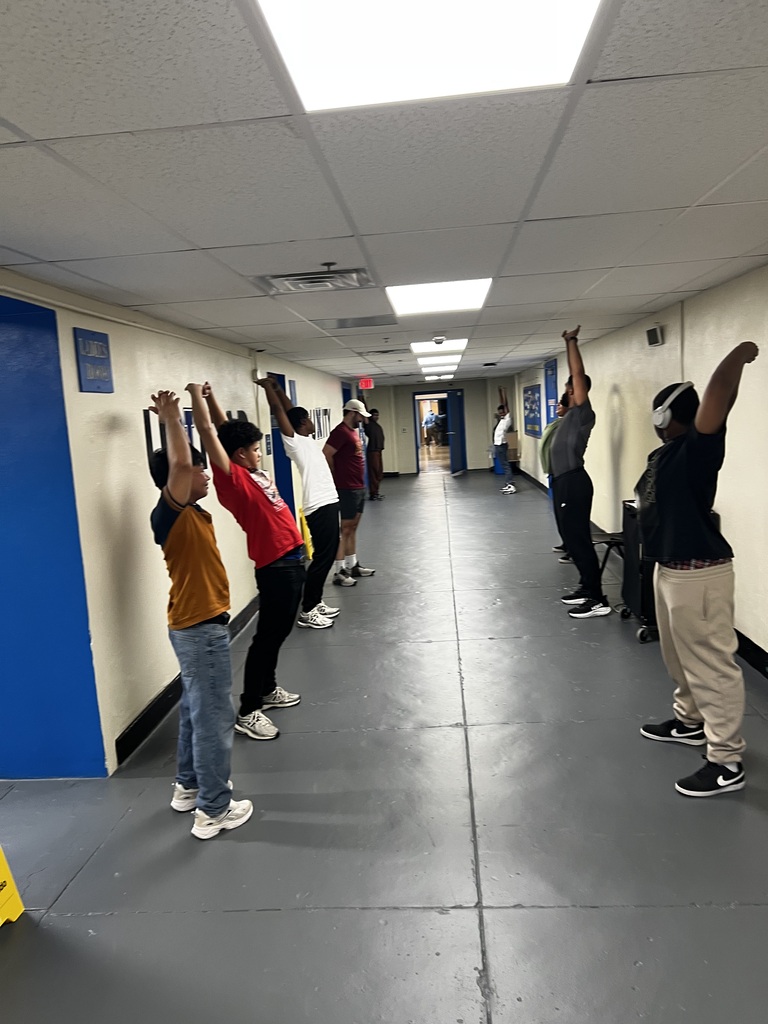 Students are stretching in the hallway as a cooldown from their workout