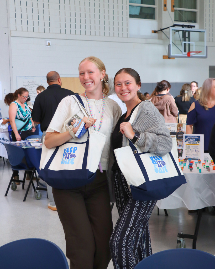 Two teachers holding up swag items they received from community partners.