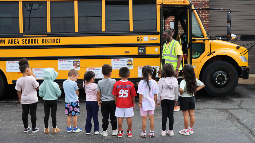 Students lined up outside listening to the bus rules.