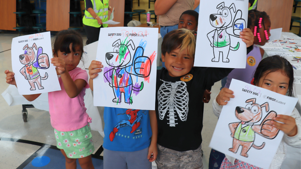 Students holding up their finished coloring pages of Safety Dog.