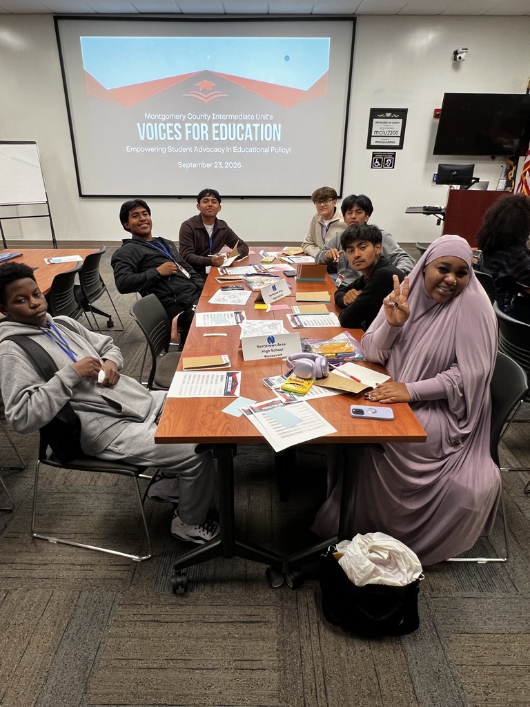 Students are posing together at a table at the MCIU