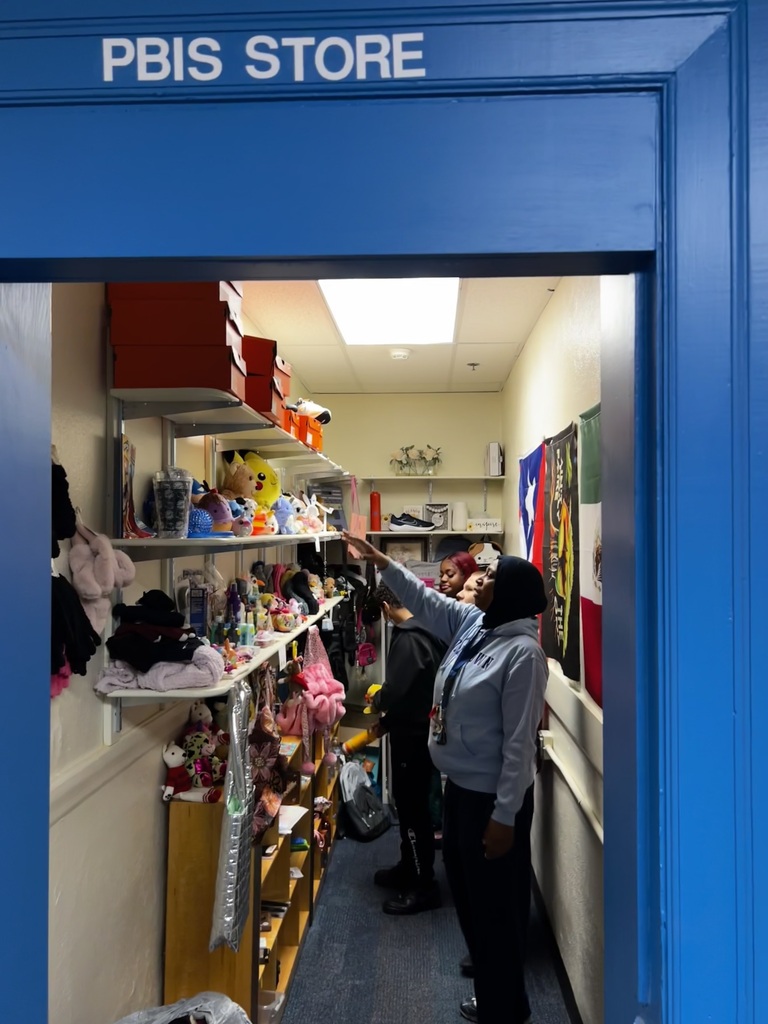 A teacher is pointing out items that can be purchased from the PBIS store and students are shopping.