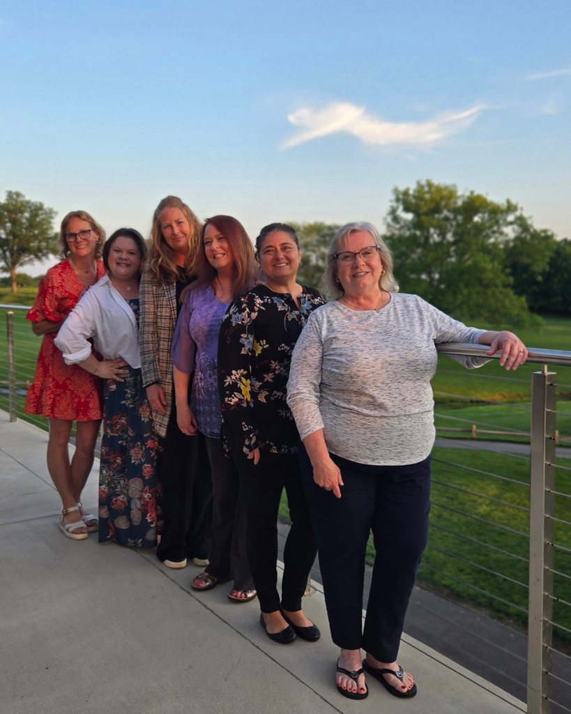 Six parents from the PCC pose for photo outside in front of railing.