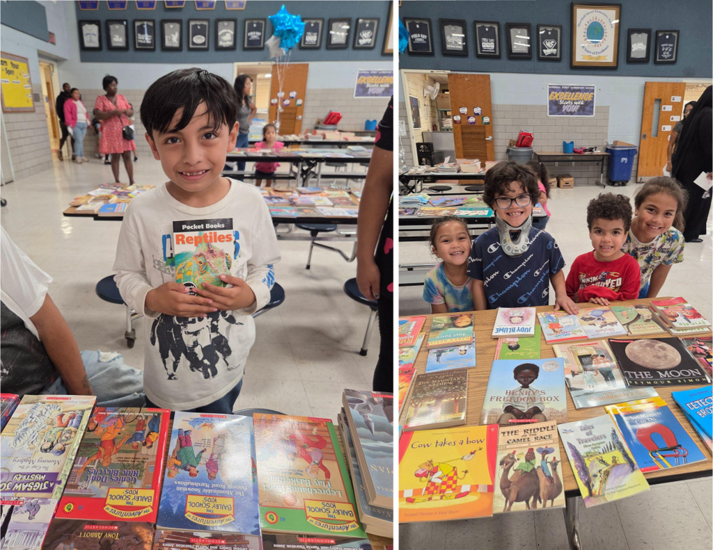 Elementary school students smile as they select books during a Back-to-School Night event.