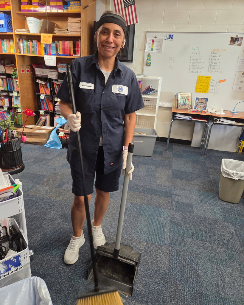 Custodian carrying broom and dustpan.