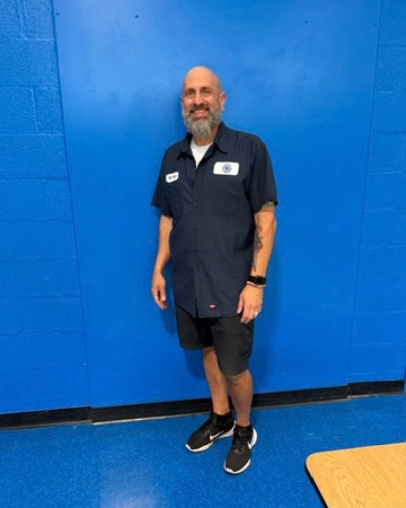 Custodian smiles for photo.
