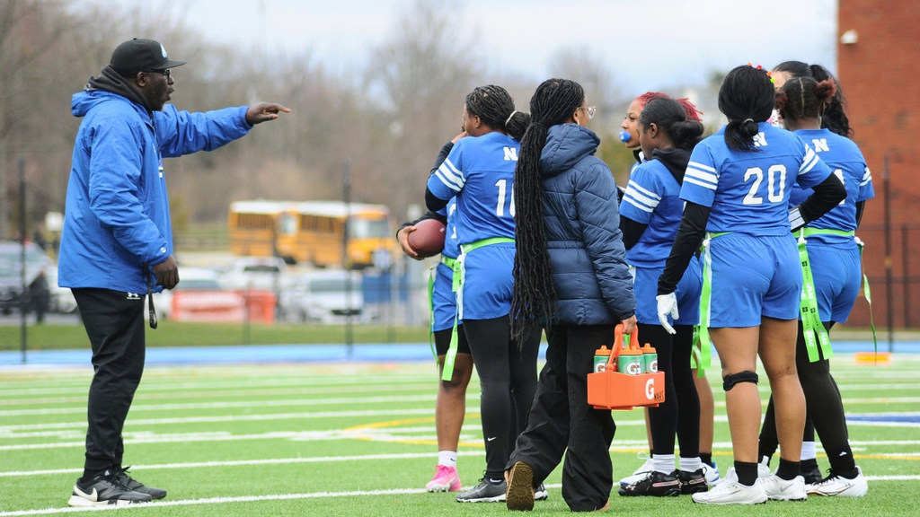 Coach talking to payers on the field.
