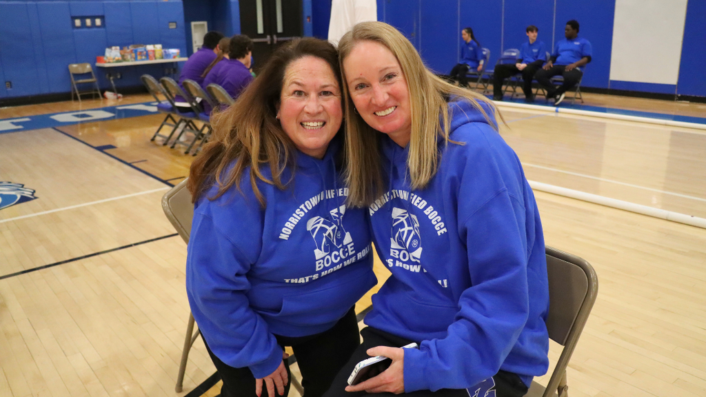 Two coaches pose for photo.