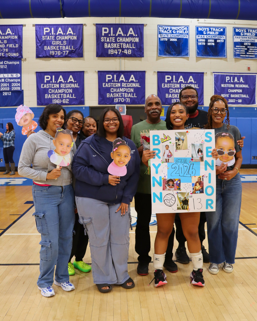 Senior athlete and family holding flowers and poster.