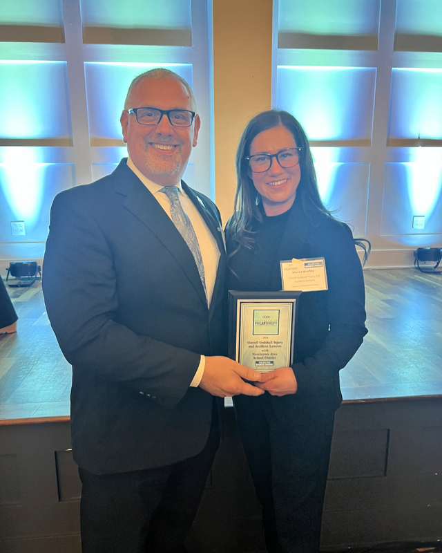 NASD Superintendent and Ostroff Godshall executive director pose for photo with award plaque.