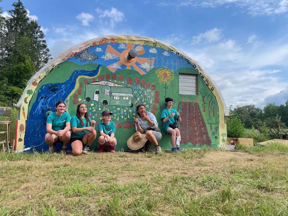 5th and 6th grade students and Farmer Molly in front of their mural creation