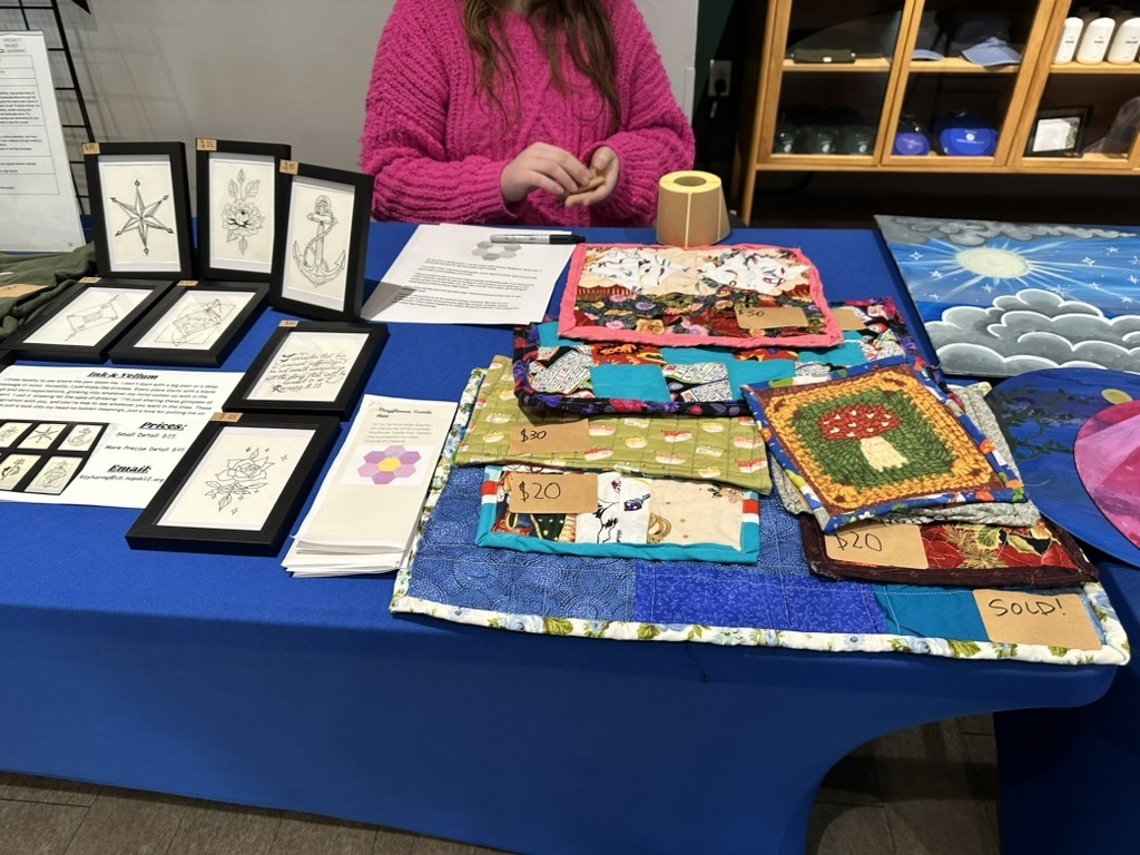 Potholders at art market with drawings at left