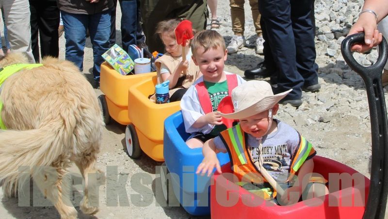 Daycare children arriving at groundbreaking in a wagon