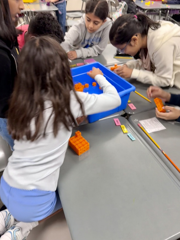 Students building rectangular prisms using unit cubes