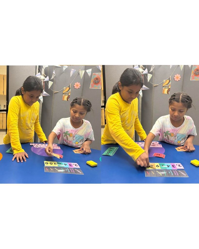 Two students at a table working together to build and read a number in the millions using place value cards.