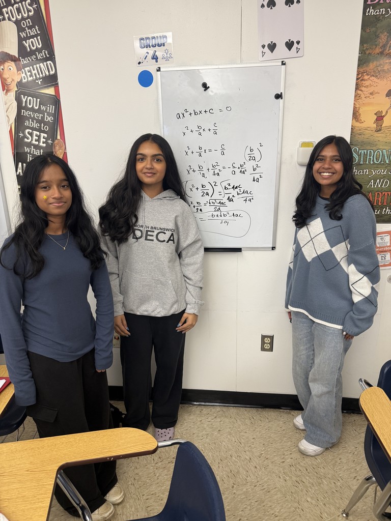 Students deriving the quadratic formula in groups at whiteboards