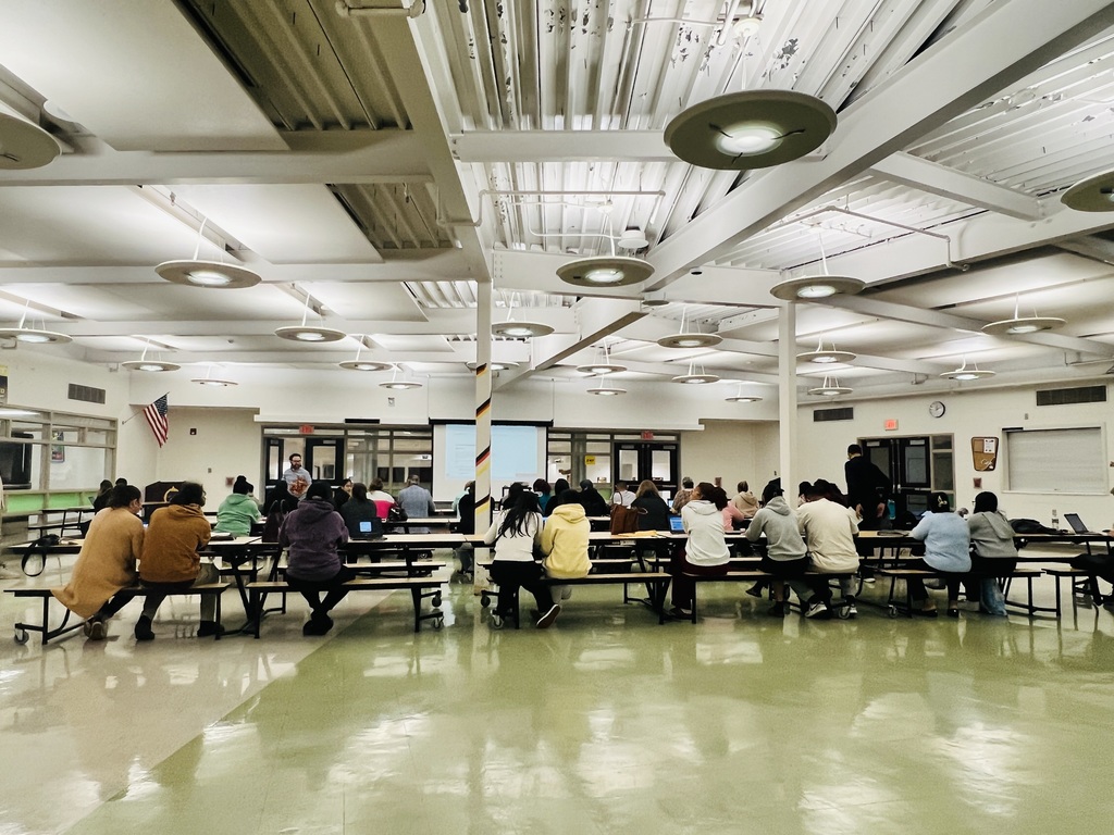parents of seniors sitting at tables filing FAFSA @ NBTHS