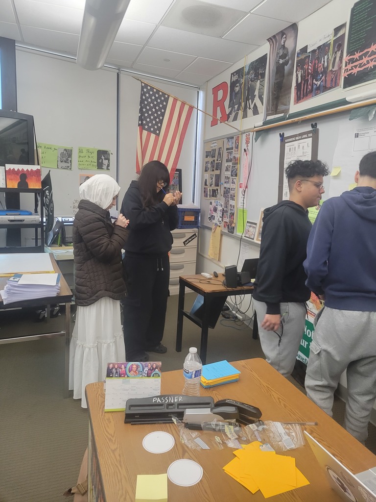 Students are writing their thoughts on sticky notes.