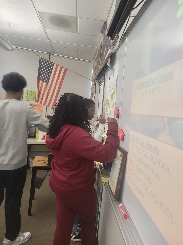 Students are writing their thoughts on sticky notes.