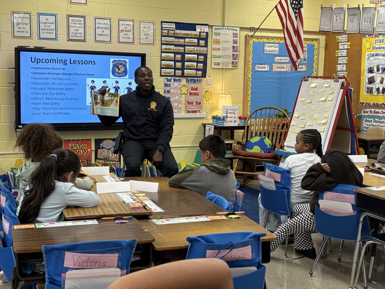 Detective Adrian reads a story to the kids.