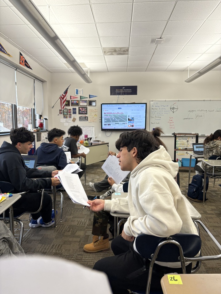 Honors English 3 students sharing close reading notes to determine mood of “Beowulf” while supporting the NB Boys Soccer team in the state  semi-final game