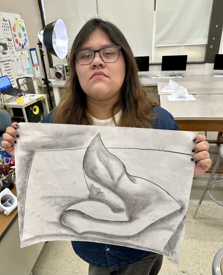 An NBTHS Art student showing their twisted paper charcoal drawing.