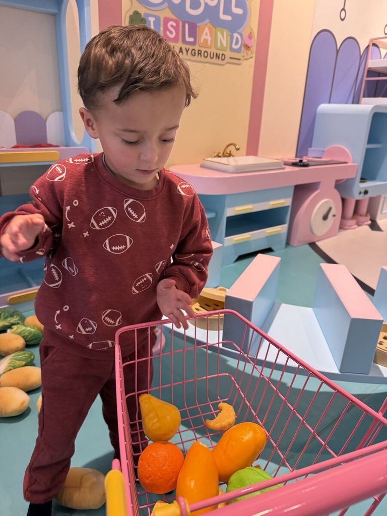 boy using shopping cart and pretend food