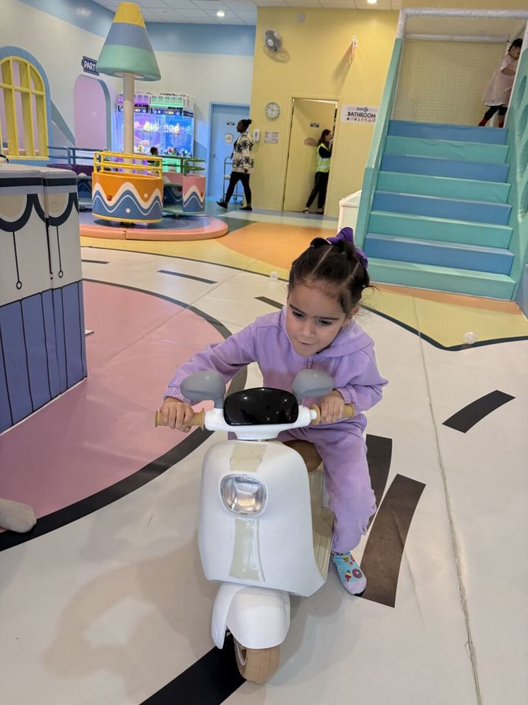 girl rides a small pretend motor bike