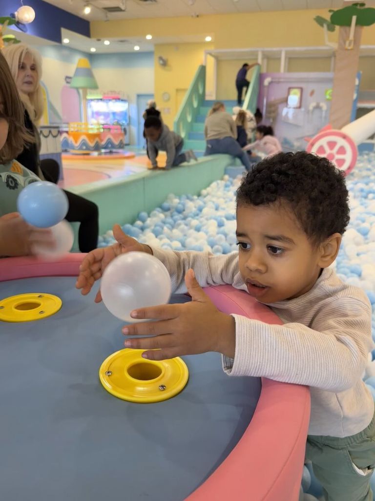 a boy watches a ball balance on the air current