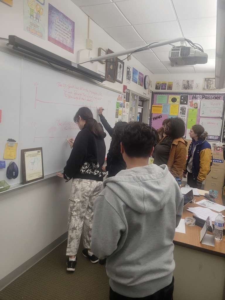 Students writing their initials on the board.
