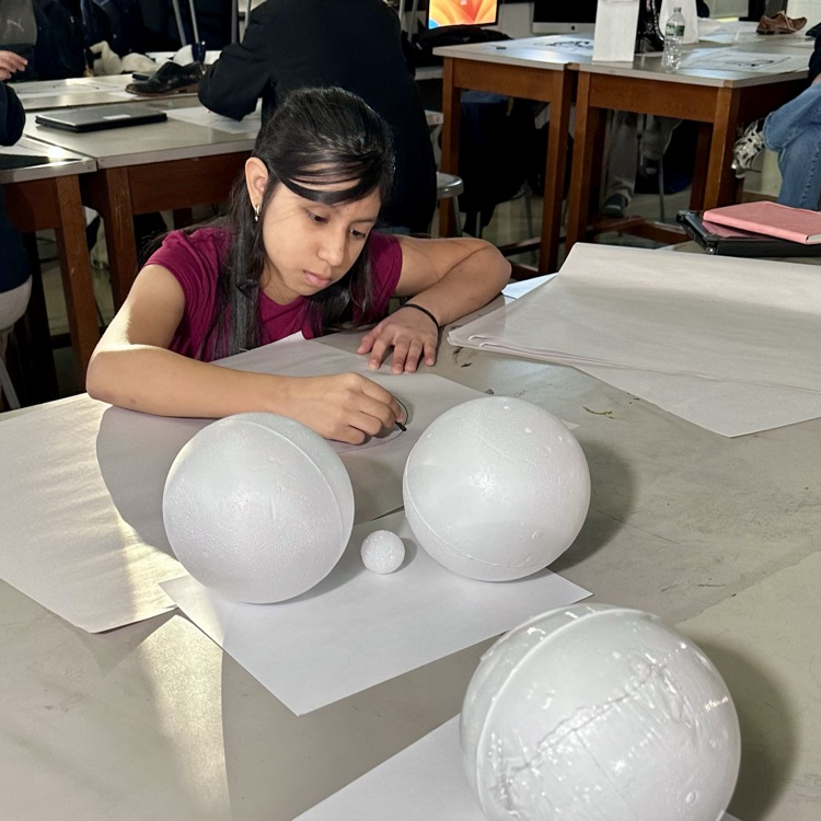 Drawing 1 students creating realistic charcoal still-life drawings.