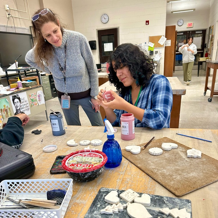 Ms. Lachow helps a National Art Honor Society  student to make holiday decorations as part of a fundraiser.