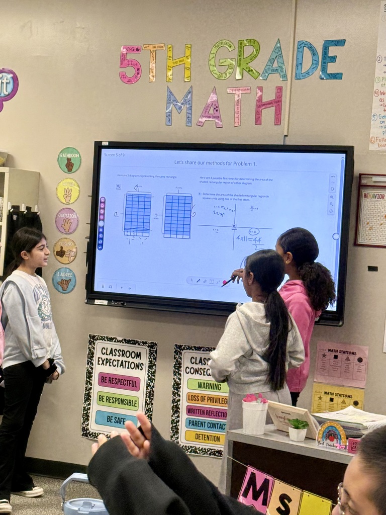Students solving math problems on the board