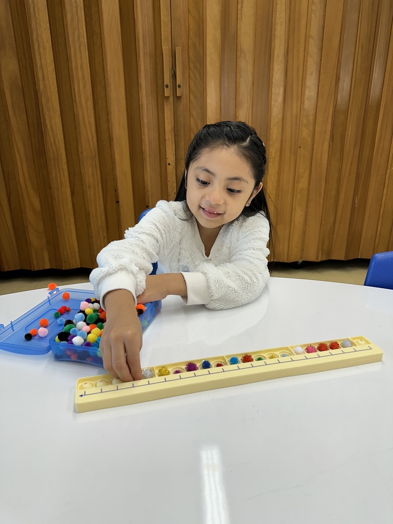In Mrs. Lucas' math class we are using mini pom poms to practice counting to 20 on our Pop It Number Line! 