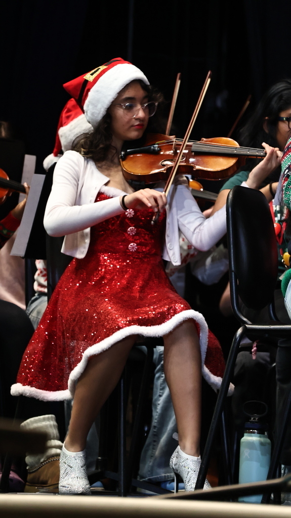 Student in festive holiday attire playing music