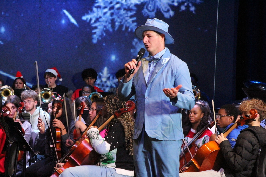 Student in festive holiday attire playing music