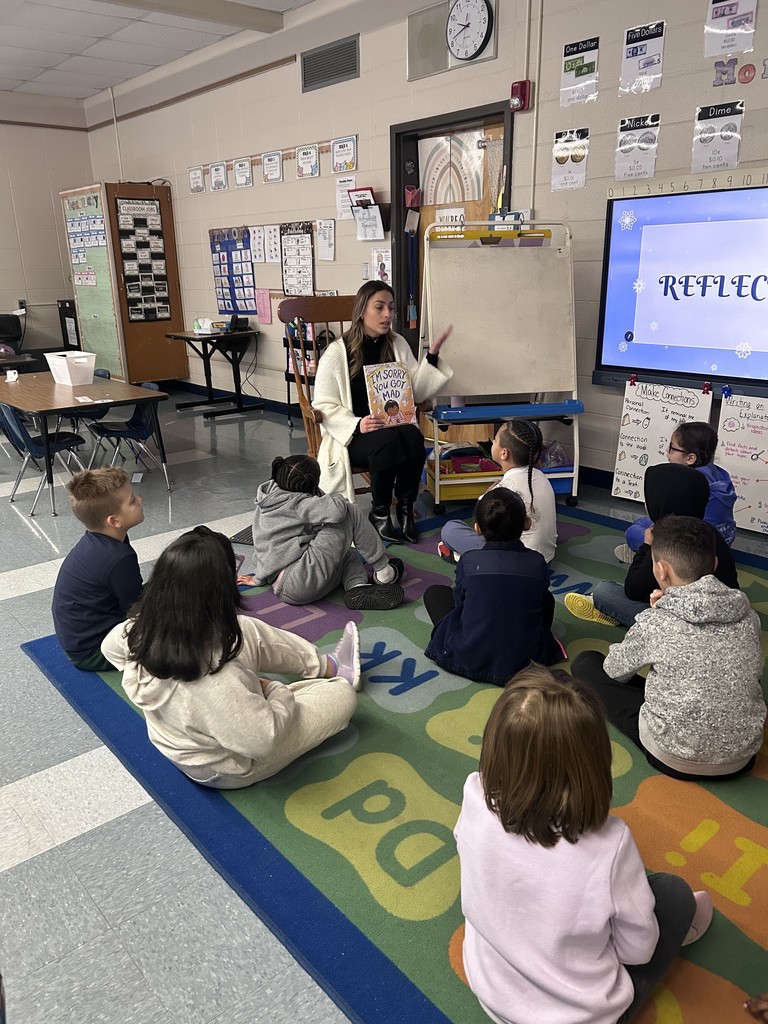Picture is Ms. Izzi reading a "I'm Sorry You Got Mad" to Mrs. Muszynski's class