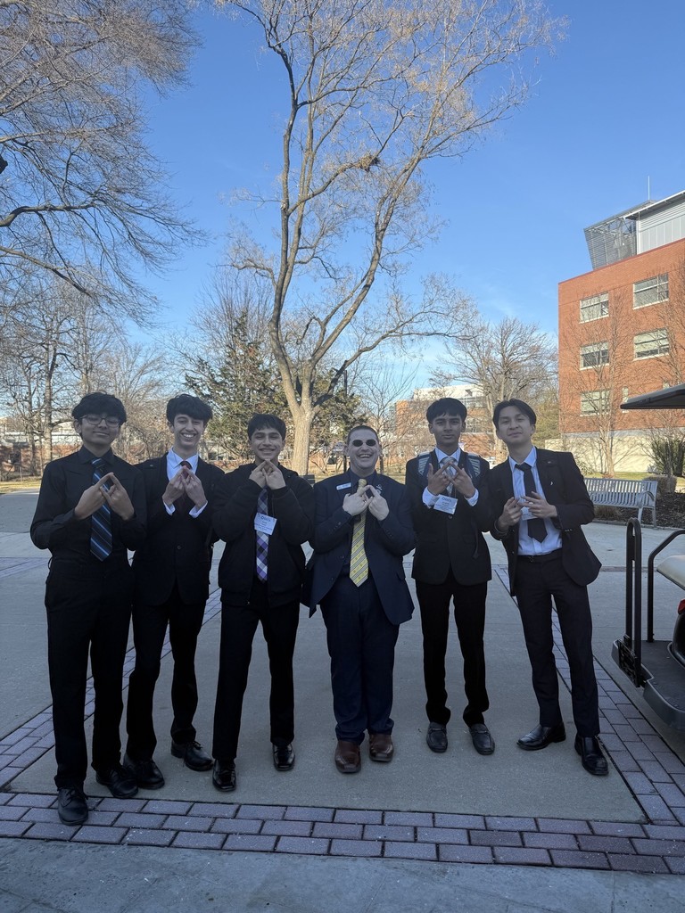 Students Posing with DECA Jeff (head of DECA) and forming the DECA symbol