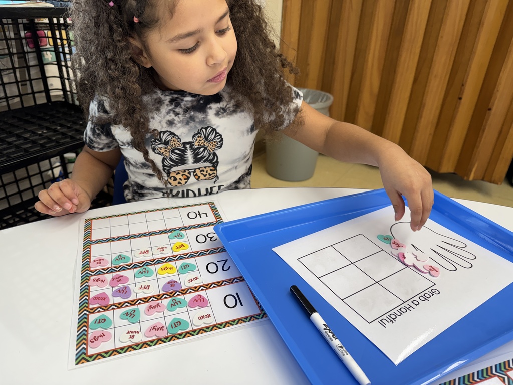 Students in Mrs. Lucas' math class were grabbing a handful of conversation heart stickers and using ten frames to count them.  Then they wrote the corresponding number on their chart.