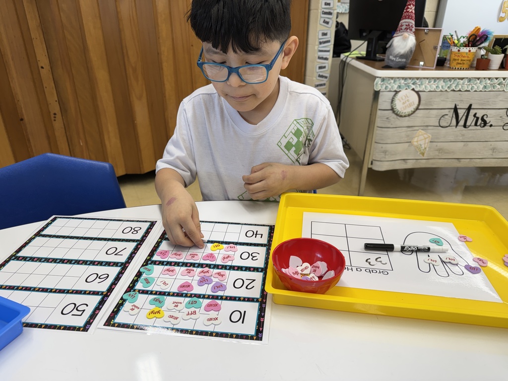 Students in Mrs. Lucas' math class were grabbing a handful of conversation heart stickers and using ten frames to count them.  Then they wrote the corresponding number on their chart.