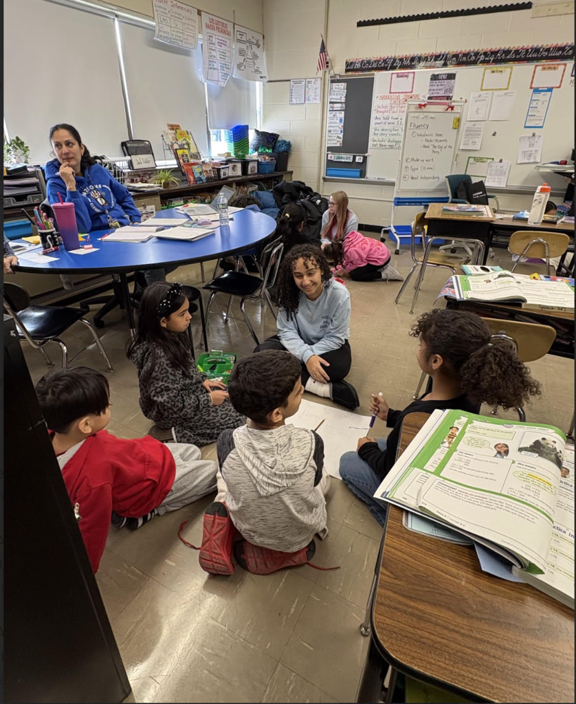Elementary students making posters with high school helpers