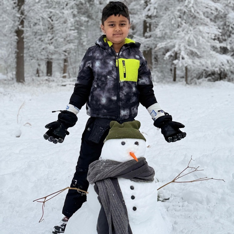 kid standing with little snowman