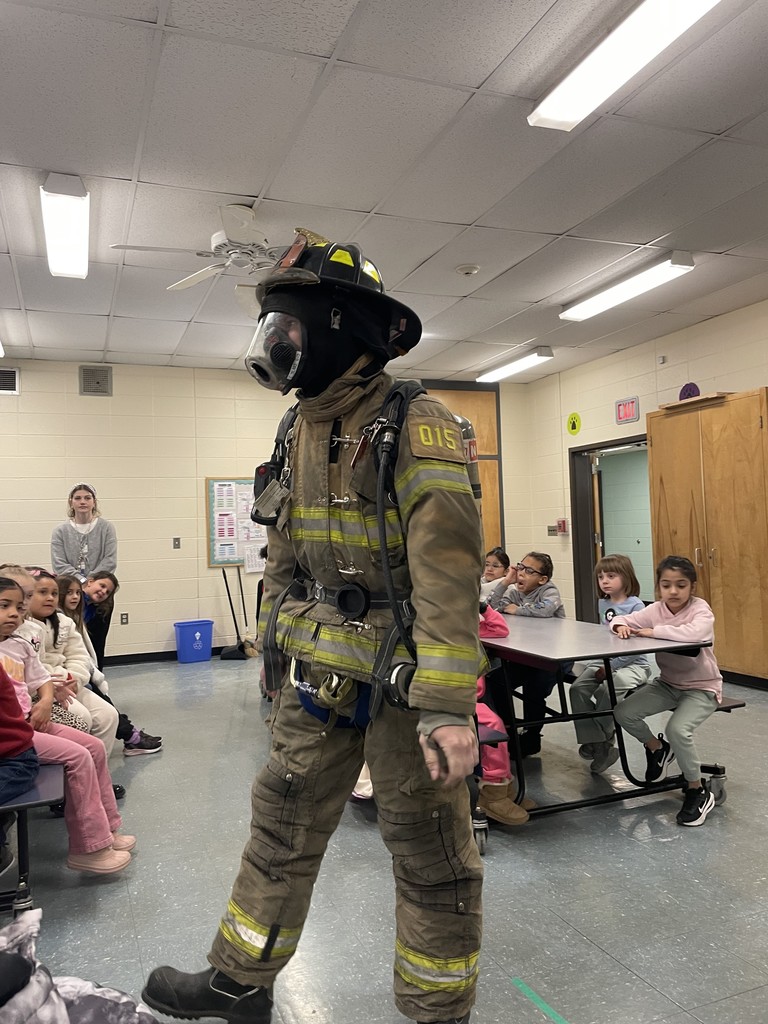 Students listening to firefighters presenting to them