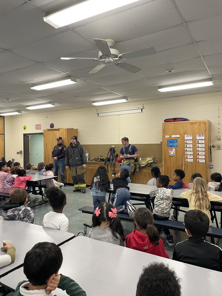 Students listening to firefighters presenting to them