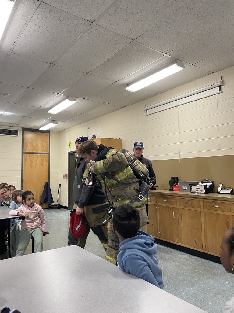 Students listening to firefighters presenting to them