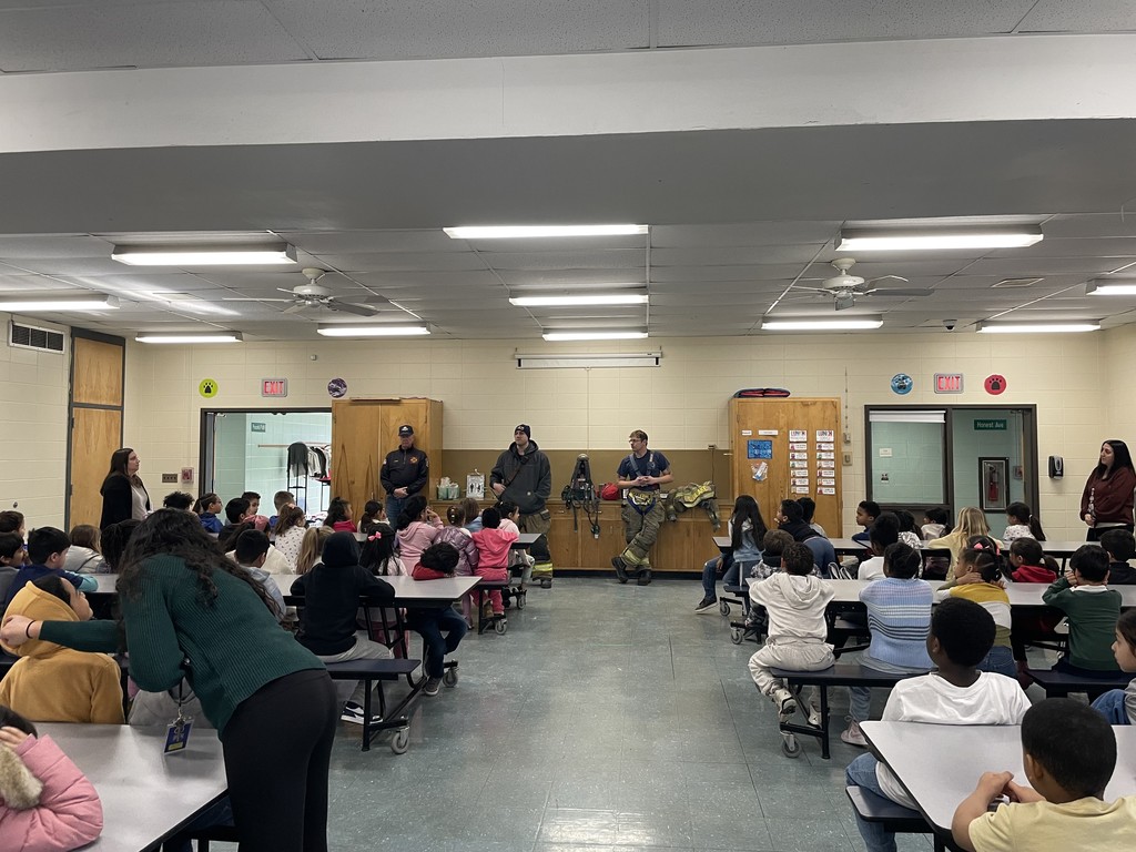 Students listening to firefighters presenting to them