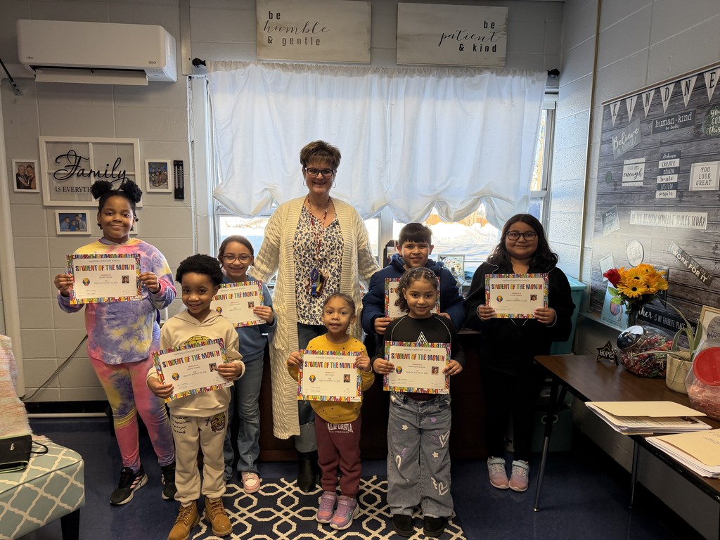 Principal standing with group of students with certificates