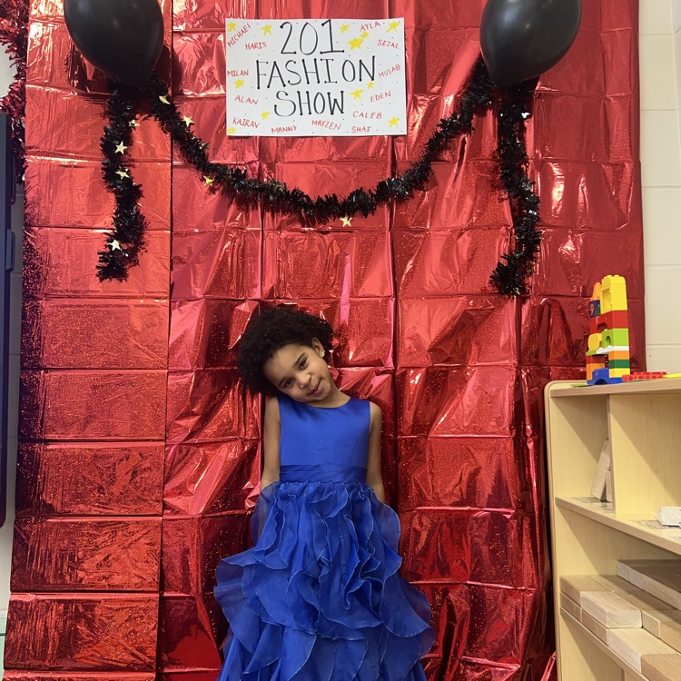 student standing in front of a red backdrop