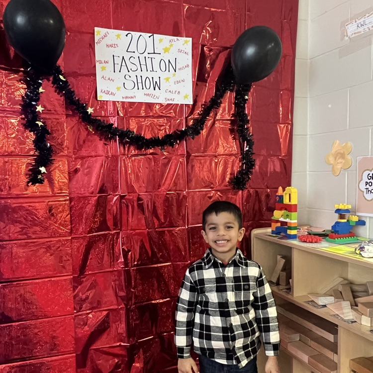 student standing in front of a red backdrop
