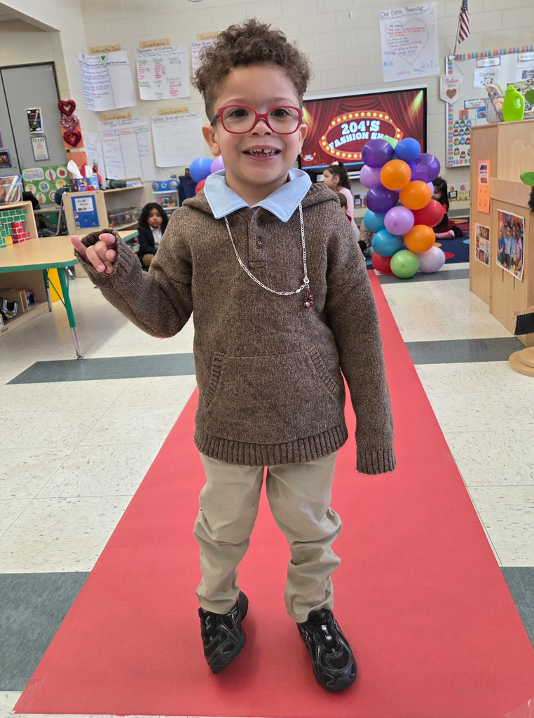 Student walking down a pretend red carpet runway